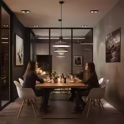 two people are sitting at a table drinking wine