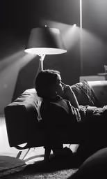 a woman on the couch in front of a lamp