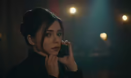 a woman is standing and talking on a cellphone