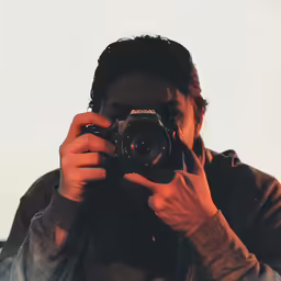 a man holding up a camera to take a picture