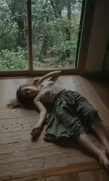 the woman is laying on the floor next to a window