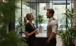 man and woman talking in modern office lobby