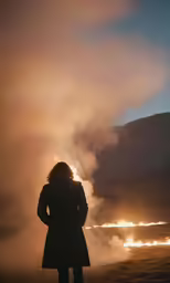 a person is standing and watching the fire