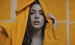 a woman is holding on to a yellow jacket