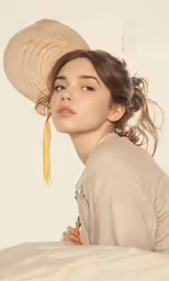a girl wearing a hat sitting on the bed