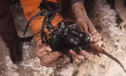 a person holding a camera while in snow