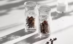 a table topped with two jars filled with beans