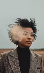 a woman in a suit looking up at the sky