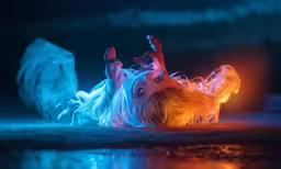 a small child lying on its side with its arms stretched out