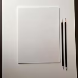 two pencils laying on top of a white square