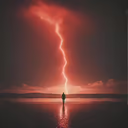 a person walks on the shore near water with lightning striking above it