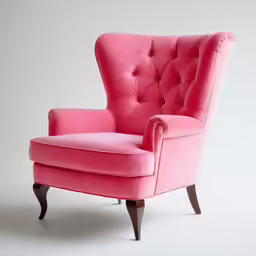 a pink chair with a black wooden legs