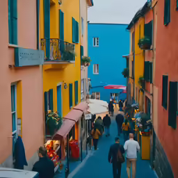 people walk down a colorful road in an old european town