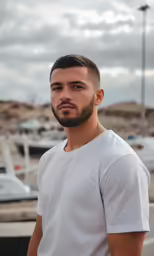 a man wearing white standing outside in a parking lot