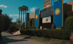 the building is blue with people walking in the background