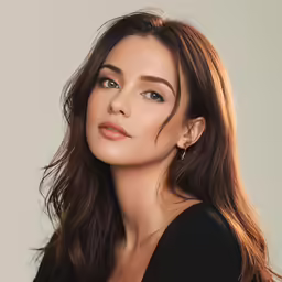 a woman with long hair wearing an open black top