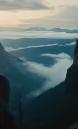 some tall mountains with fog covering the valleys