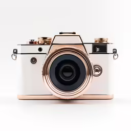 a golden and white camera sitting on a table