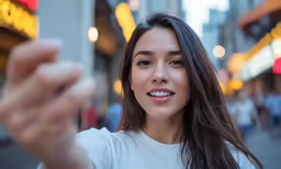 a woman with long hair standing in front of a building holding her fist up