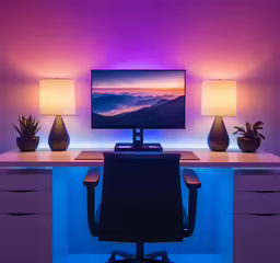 a computer screen and desk with a desktop lamp on top