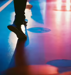 the legs of a person standing on top of a shiny floor