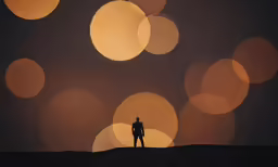 the silhouette of a person stands in front of round bubbles in the air