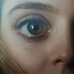 an extreme close up of an eye with a feather