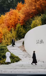 a woman walking down steps that lead to a wall