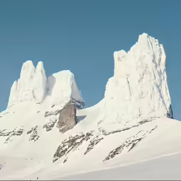 the mountains are covered in snow and tall