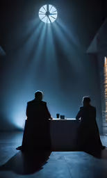 two men sit at a table as light beams shine in the background