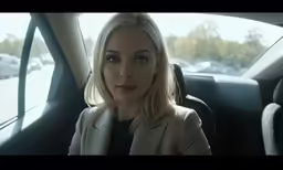 a beautiful blond woman sitting in the backseat
