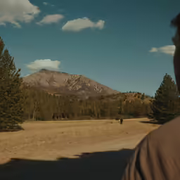 a man looking at a mountain in the distance