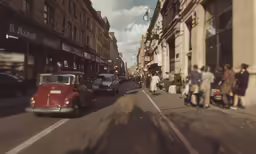 a view of the side of a street with cars, people and luggage