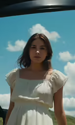 woman in white dress standing on a grassy field