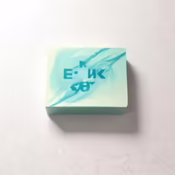 a square soap bar with some blue ink on it