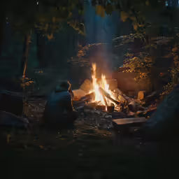 a man sits in front of a fire at night