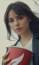 a woman with a leather jacket holding a mug