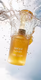 a close up image of water splashing over a bottle of kolar louis