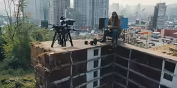a person sitting on top of a concrete slab in the middle of a large city