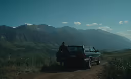 the man is standing by his suv waiting for someone