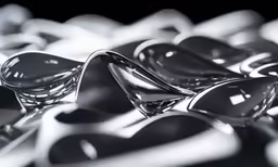 several shiny chrome spoons sit together on a table