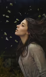 a woman wearing a gray shirt and flying butterflies