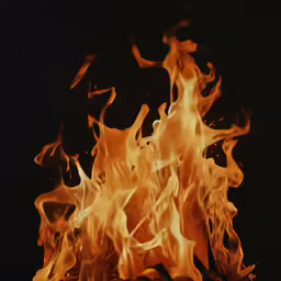 a fire with lots of orange flames in the dark