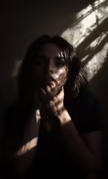 a woman poses for a portrait in an dim room