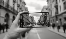 someone holding up their phone to take a picture of street