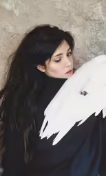 a woman with black hair and dark clothes