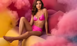 a woman in pink underwear is sitting on an object