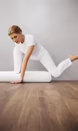 a young woman is practicing yoga in the middle of a floor