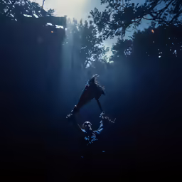 silhouettes of two people in the dark with a street light and trees