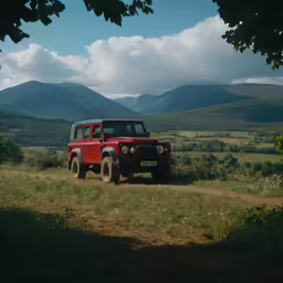 a red vehicle parked in the middle of a mountain range